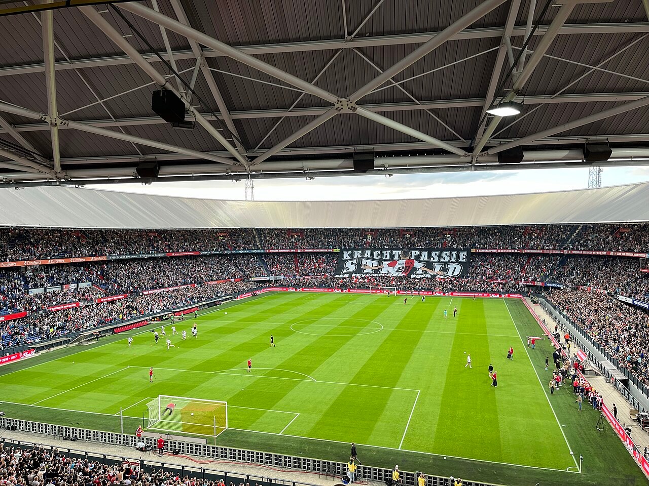 The inside of De Kuip in Rotterdam, packed, with a banner reading Kracht Passie Strijd across the far end